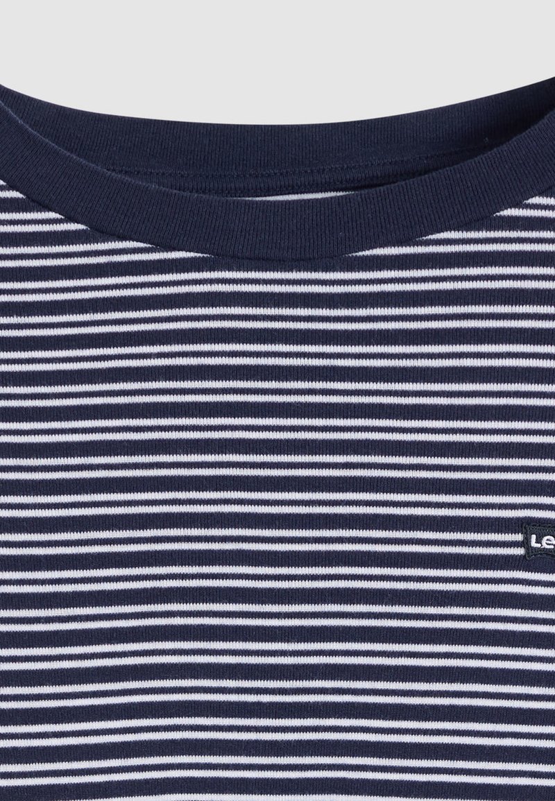 Maglietta a righe blu navy e bianche con collo rotondo, realizzata in tessuto morbido. Presenta un piccolo logo vicino all'orlo. Texture liscia.