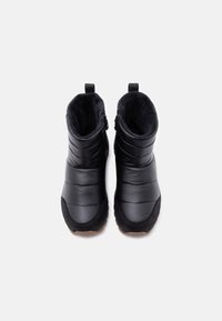 Ζευγάρι μαύρες μονωμένες χειμερινές μπότες με επενδυμένες πλευρές, σουεδένιες άκρες δαχτύλων και απαλό εσωτερικό επένδυμα, ορατές από πάνω σε λευκό φόντο.