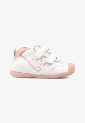 Zapatillas blancas para niños pequeños con acentos en rosa, doble correa de Velcro, punta redonda y suela texturizada. Logo en el talón y en el lateral. Material suave y duradero.