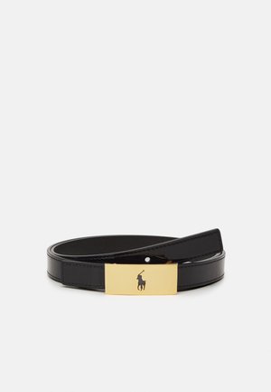 Zwarte leren riem opgerold met een rechthoekige gouden gesp met een silhouet van een polospeler te paard.