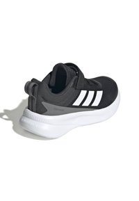Chaussure de sport noire avec une tige en maille, un design à trois bandes blanches, une sangle ajustable et une semelle en mousse blanche. Présente des accents texturés.