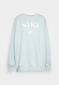Světle modrá volnější mikina s bílým nápisem "NIKE Athletic dept. 1972" a logem Nike Swoosh na přední straně.