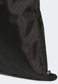 Black nylon bag with a smooth texture, featuring a side zipper, woven accents, and a small logo tag near the base.