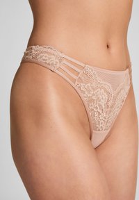 Kant en mesh hipsterondergoed in nude, met zijkanten en bloemenkantdetails, een soepele textuur en naadloze afwerking.