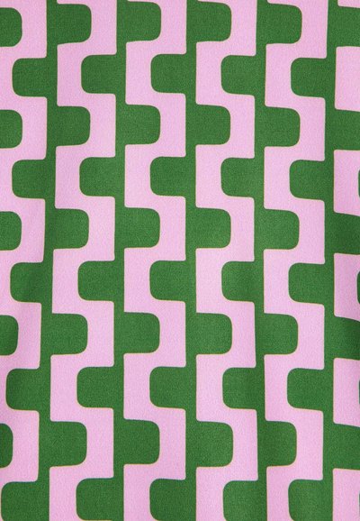 Ein Textil mit einem sich wiederholenden geometrischen Muster aus grünen und rosa Formen, die sich wie ineinandergreifende Kurven auf einer glatten Stoffoberfläche präsentieren.