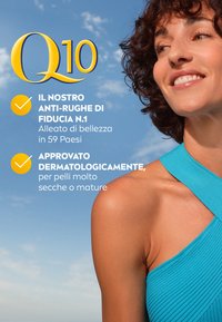 Top a righe blu brillante, con un design incrociato sullo scollo, in contrasto con il tono caldo della pelle contro uno sfondo di cielo blu.
