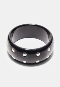 Črni plastični obroč z bleščečim zaključkom, okrašen s srebrnimi kovinskimi zaponkami, enakomerno razporejenimi po zunanji strani. Gladke teksture in okrogle oblike.