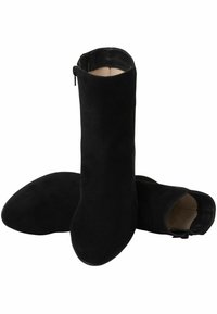 Stivaletti neri in suede con una texture liscia, punta rotonda e chiusura con zip sul lato esterno. Progettati con una silhouette aderente.