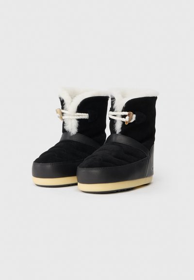 Botas de invierno de ante negro con forro de piel blanca, superficie texturizada y suela de goma color crema. Presentan un detalle decorativo con cordón y toggles.