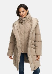 Manteau enveloppant beige avec un col montant, fermeture éclair et poches latérales. Présente un design matelassé et une texture douce pour la chaleur.
