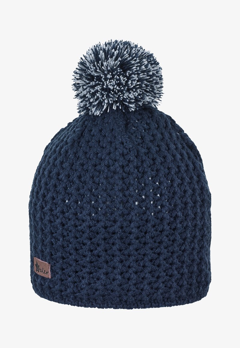 Marineblaue Strickmütze mit strukturiertem Muster und großem zweifarbigen Bommel oben, mit einem kleinen braunen Stoffetikett an der Seite.