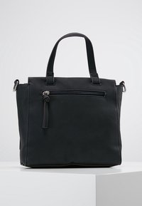 Svart läderhandväska med korta handtag, dragkedjeförsedd framficka, fyrkantig form, strukturerad yta och silverfärgade detaljer.