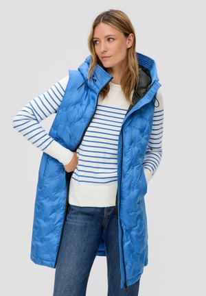 Blauer gesteppter langer Weste mit Kapuze, ausgestattet mit einem Reißverschluss vorne und schwarzem Futter, kombiniert mit einem weiß-blauen gestreiften Pullover.