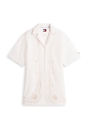 Balta īsroku pogājama krekls ar ziedu izšuvumiem priekšpusē un apkaklē, ar nelielu logotipu kreisajā piedurknē.