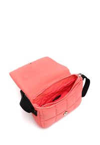 Korálová prošívaná crossbody taška s černým nastavitelným popruhem, klopou se sklopným zapínáním a vnitřní kapsou na zip.