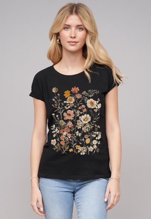 T-shirt noir avec un imprimé floral dans des couleurs variées, y compris l'orange, le jaune et la crème ; manches courtes, col rond, en coton.