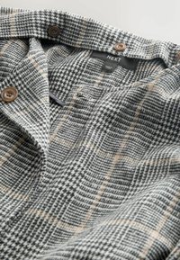 Hall ja beezi tooni hundikoera hambamustriga kangas kahe pruuni nupuga ja sildiga. Pehme tekstuur ja kohandatud disain.