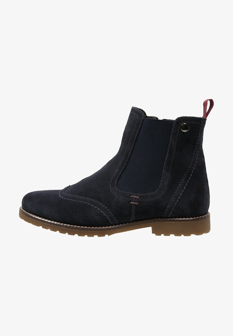 Bottines en daim bleu marine avec panneau latéral élastique, semelle en caoutchouc beige, détails de couture et languette à l'arrière pour un enfilage facile.