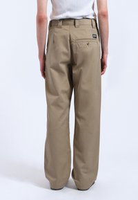 Khaki wijde broek van een gestructureerde stof, met een achterzak en een tailleband met lusjes. Glad afgewerkt, duurzaam ontwerp en minimale branding.