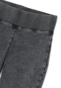 Grijze denim leggings met een geribde zwarte tailleband, uitgerust met een zachte textuur en nette stiksels langs de naden.