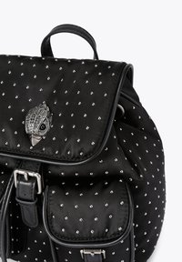 Czarny plecak z satyny z dodatkami w postaci srebrnych ćwieków, z ozdobnym zapięciem w kształcie sowy, regulowanymi paskami i dwoma przednimi kieszeniami.