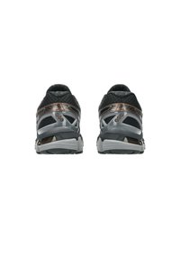 Sneakers atletiche in mesh nero e grigio con accenti metallici a contrasto. Suola ammortizzata con supporto visibile al tallone e finitura testurizzata.
