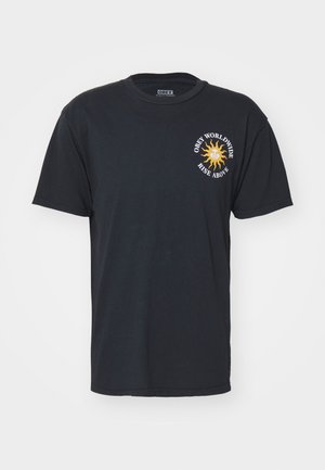 Črna bombažna majica s kratkimi rokavi z okroglo izrezom. Sprednji grafični motiv vključuje sončno zasnovo in besedilo: "Obey Worldwide Rise Above."
