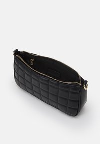 Borsa rettangolare nera trapuntata con zip dorata parzialmente aperta, che mostra una tasca interna con zip e foderatura liscia.