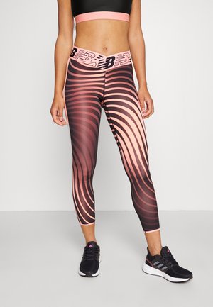 Leggings con un motivo vorticoso in nero e corallo, realizzati in materiale elasticizzato, con una vita larga decorata con un logo e una lunghezza alla caviglia.
