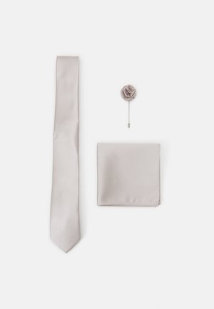 Light gray satin tie, matching pocket square, and a fabric rose lapel pin, all with smooth textures and subtle sheen.
