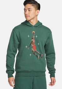 Felpa verde con cappuccio che presenta una grafica pixelata di un giocatore di basket, progettata con una tasca a marsupio e polsini a coste.