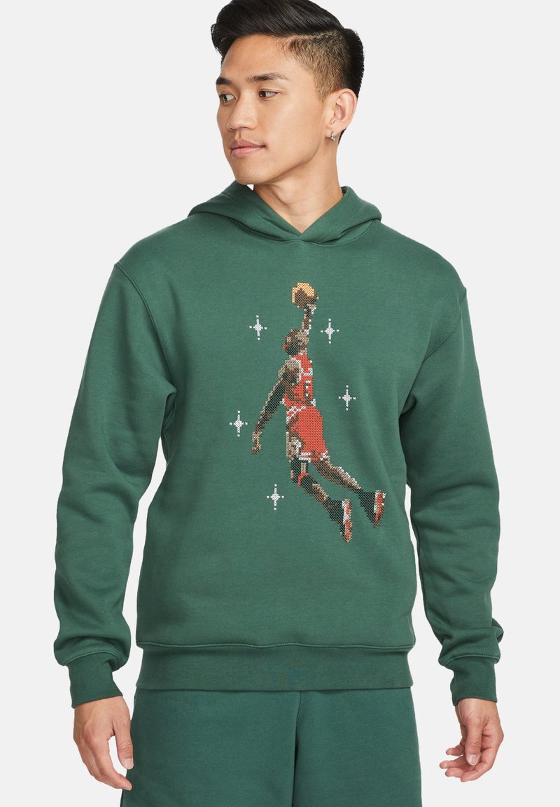 Felpa verde con cappuccio che presenta una grafica pixelata di un giocatore di basket, progettata con una tasca a marsupio e polsini a coste.