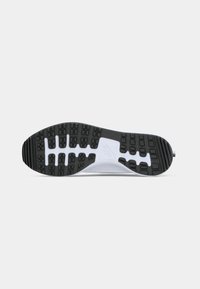 Black rubber sneaker sole with textured grip patterns, white midsole, and branding detail. Flat profile with curved edges for comfort.