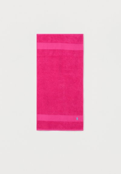 Φωτεινή ροζ ορθογώνια πετσέτα με μονόχρωμο σχέδιο και δύο οριζόντιες λωρίδες, με ένα μικρό μπλε κεντητό λογότυπο κοντά στην κάτω άκρη.