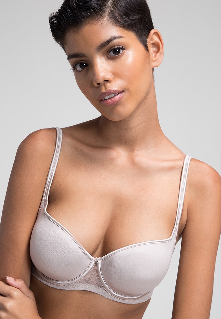 Sostén color beige con aros, detalles de malla, tirantes delgados ajustables y un diseño de copa moldeada con un sutil brillo y costuras planas.