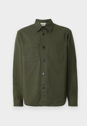 Chemise boutonnée vert foncé en tissu doux, dotée d'un col, de deux poches poitrine et de boutons noirs le long de la patte de boutonnage.