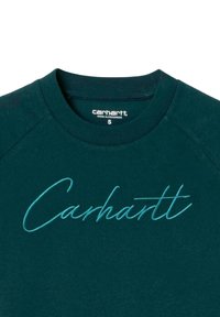 Sudadera verde azulado con un escote redondeado, que presenta un logo en cursiva "Carhartt" bordado en azul en el pecho. Mangas cortas tipo raglán.