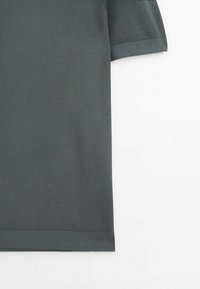 Chemise en maille texturée gris foncé à manches courtes avec ourlet et poignets côtelés, présentée sur un fond blanc uni.