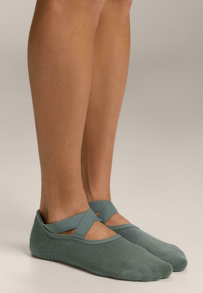 Zelene balerinke od pamuka s križnim trakama, s mekanom teksturom i niskim profilom, dizajnirane za udobnost i lakoću nošenja.