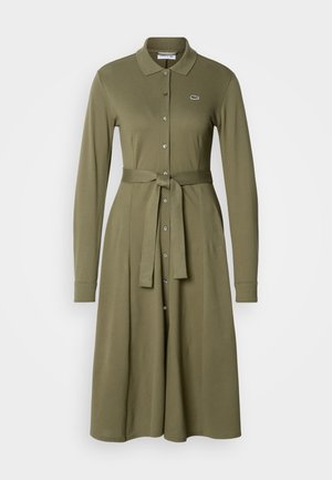 Vestido khaki de manga longa, com gola, fecho de botões à frente, cintura cintada, tecido texturizado, saia rodada e pequeno logotipo no lado esquerdo do peito.