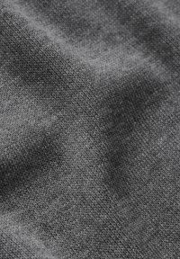 Il tessuto di maglia grigio presenta una texture morbida con una trama fine. Il materiale appare liscio con leggere variazioni di tonalità.