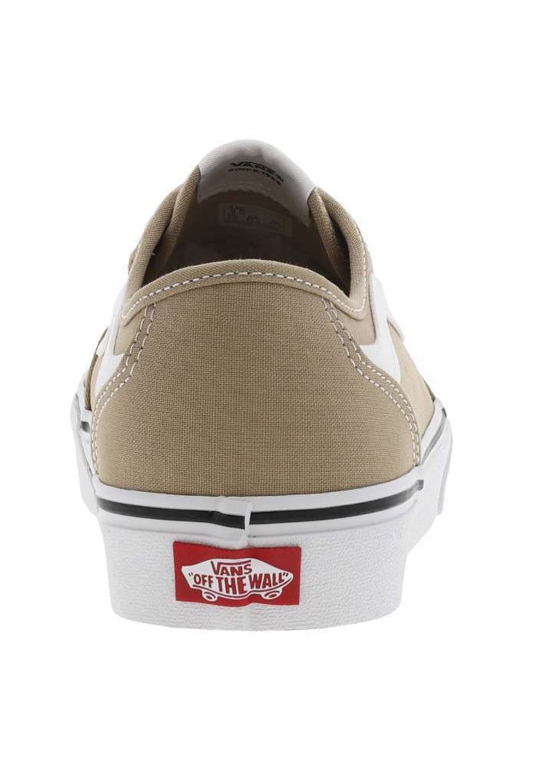 Beżowe sneakersy z płótna z białymi akcentami, czarnym wykończeniem i gumową podeszwą. Zawierają czerwoną naszywkę z logo Vans na pięcie. Szczegóły podwójnego przeszycia.