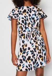 Robe à imprimé léopard en rose, noir, bleu et jaune ; manches courtes évasées et détail de taille nouée ; tissu léger et coupe décontractée.