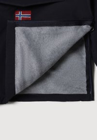 Marineblauwe jas met grijs fleece binnenvoering, voorzien van een ritszak en een klein Noors vlaggenpatroon aan de bovenkant links.