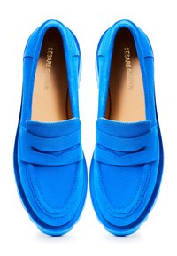 Paire de mocassins en daim bleu vif avec bride penny, bout arrondi et semelles intérieures marron marquées, vus de dessus sur fond blanc.