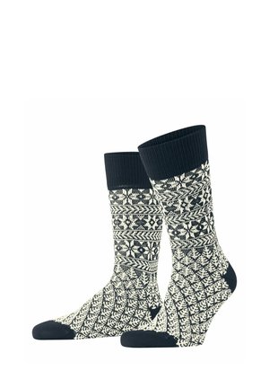 Kniestrümpfe in Schwarz-Weiß mit geometrischen und floralen Mustern und einfarbigen schwarzen Bündchen, Fersen und Zehen.