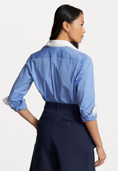 Deolinda 25735 Lyon Polo Shirt with Blue Trousers In Stock Now