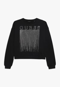 Felpa nera con un design cropped e scollatura tonda, decorata con strass argentati che formano la parola "GUESS" e motivi verticali.