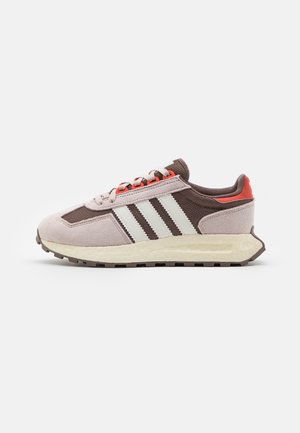 Baskets en nubuck marron avec des rayures blanches, des accents rouges et un dessus en mesh texturé. Présentent un col rembourré et une semelle de couleur claire.