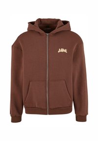 Ruda užtraukiama šviesi sukelta, pagaminta iš švelnios medžiagos. Juosmens kišenė, raukšlėti rankogaliai ir šviesios spalvos logotipas ant krūtinės.